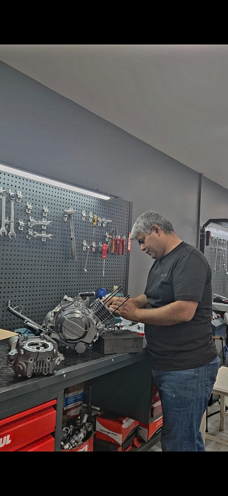 Motosiklet motor bloğu üzerinde bakım yapan usta